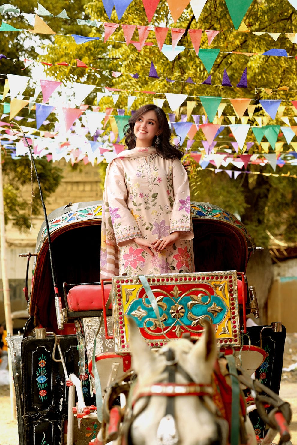 "Woman wearing embroidered lawn suit near rickshaw"